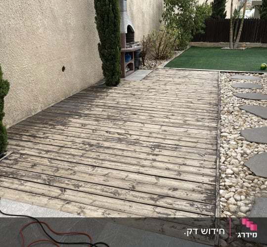 דק עץ עם שביל אבנים וחצר דשא מלאכותי